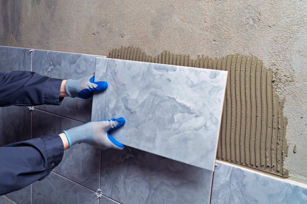 A,Worker,Glues,A,Tile,To,A,Wall.,Finishing,Work